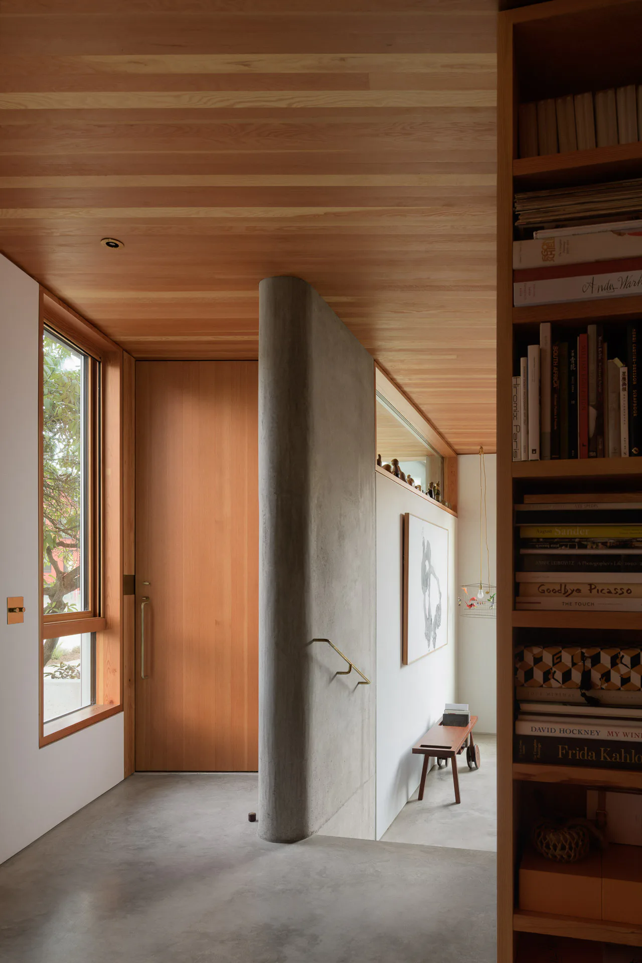 A rounded wall next to the main door separates the entrance area from the lower-level living area.