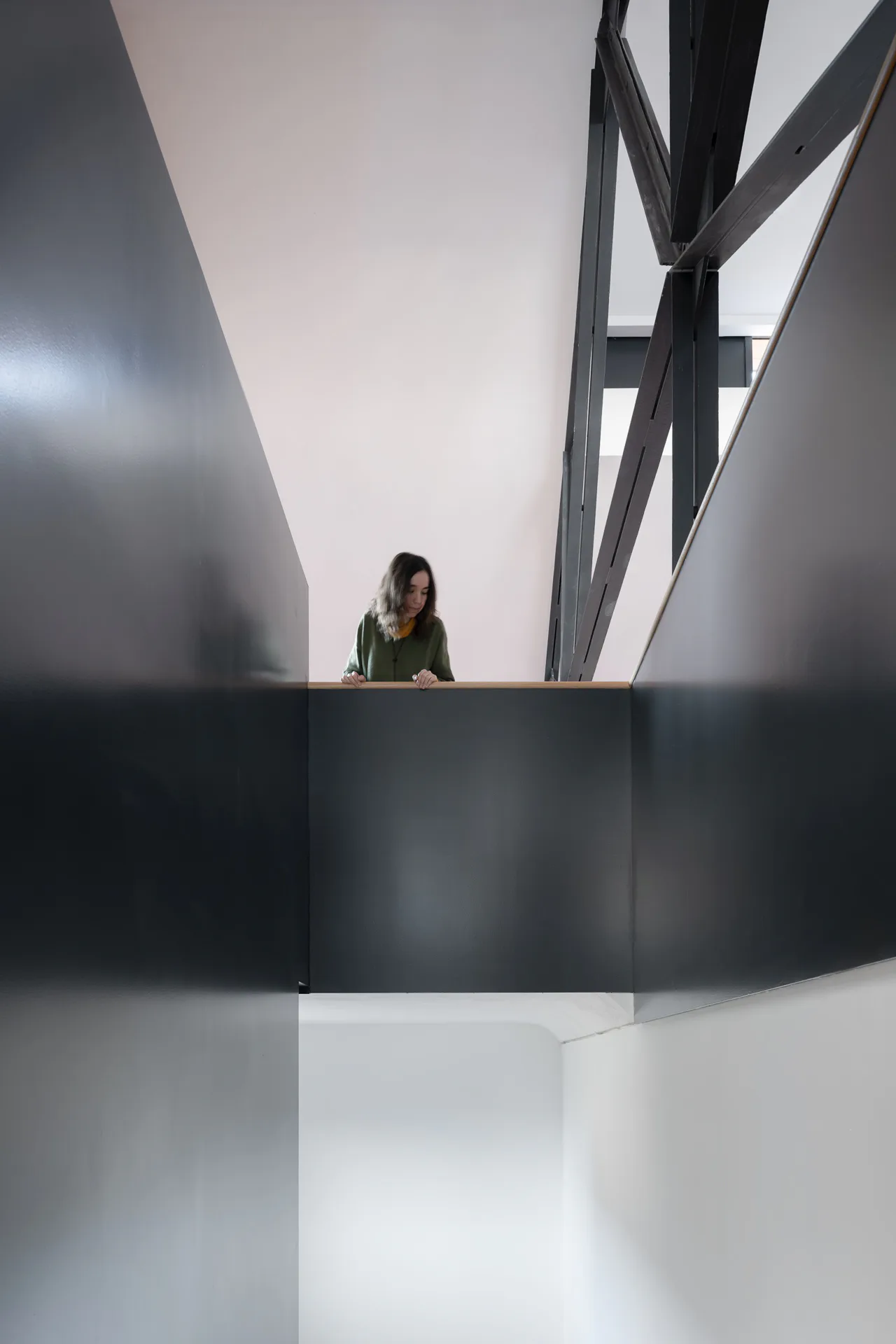 Die skulpturale Stahltreppe nimmt die Materialität der Bestandsbauteile auf.