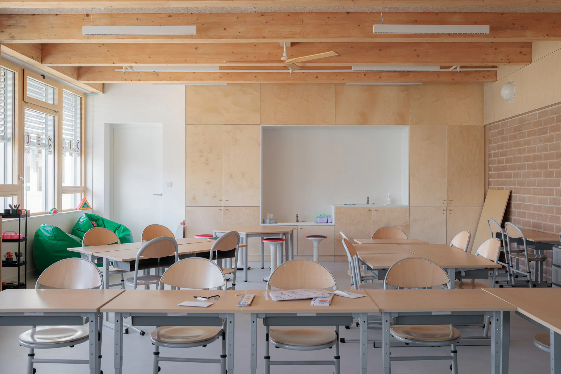 Die Waschbecken sind in Einbaumöbeln der Klassenzimmer integriert. Die einheitliche Verkleidung aus Pappel-Sperrholzplatten schafft eine ruhige Atmosphäre im Klassenzimmer.