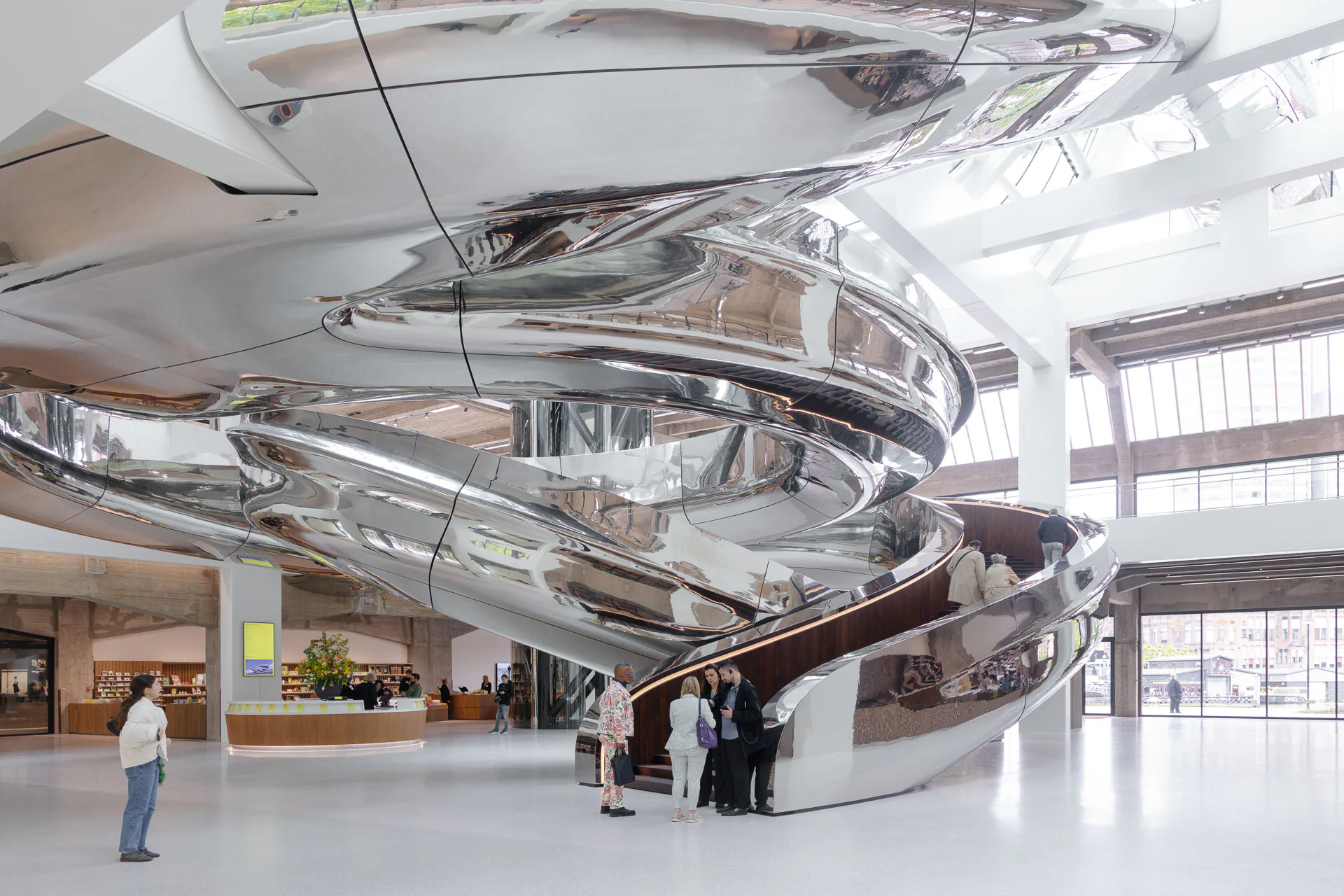 Die doppelt gewundene Treppenskulptur aus poliertem Edelstahl führt ins zentrale Atrium.