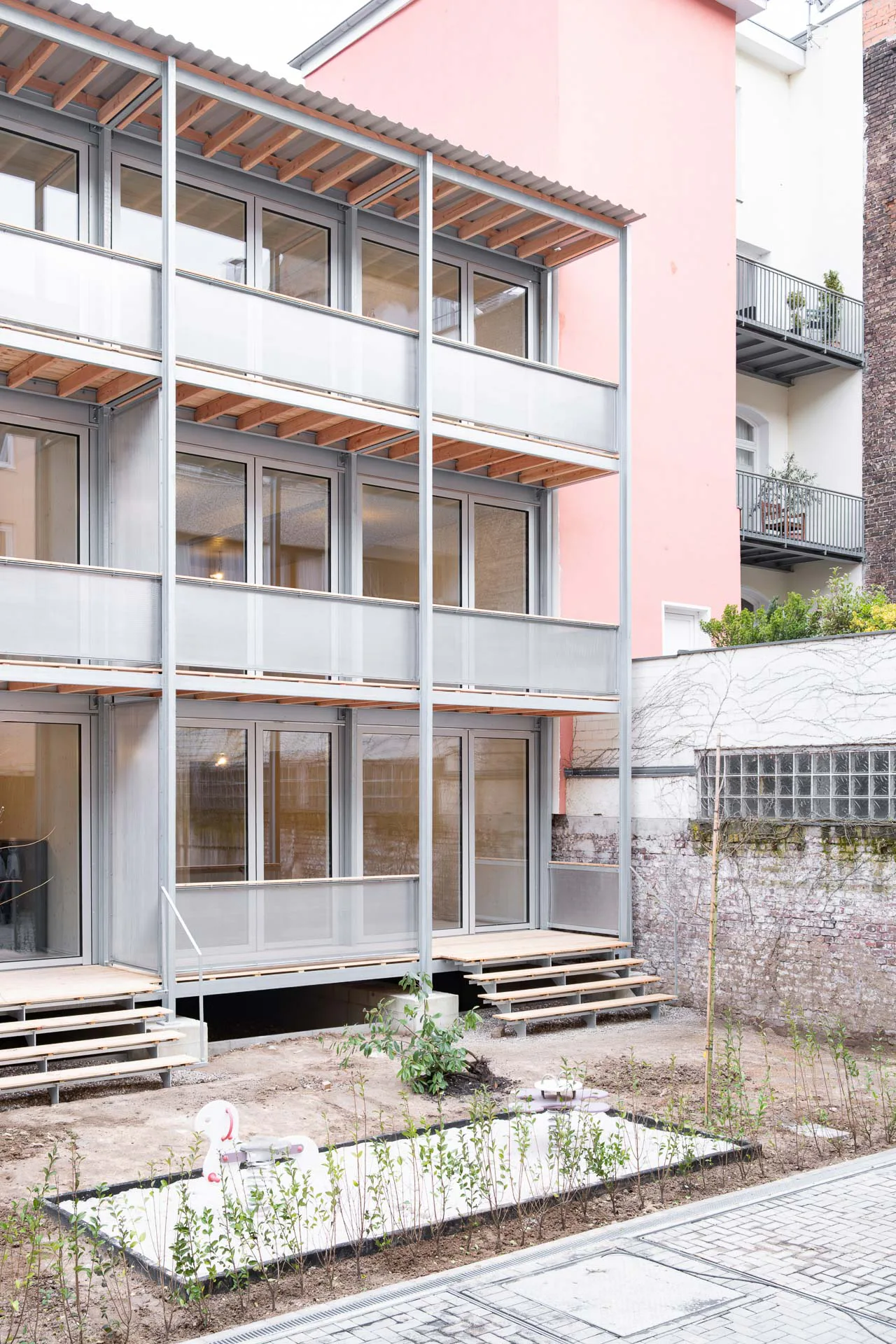 Die verzinkte Stahlkonstruktion der Balkone korrespondiert mit den Holz-Aluminiumrahmen der Fensterfront.