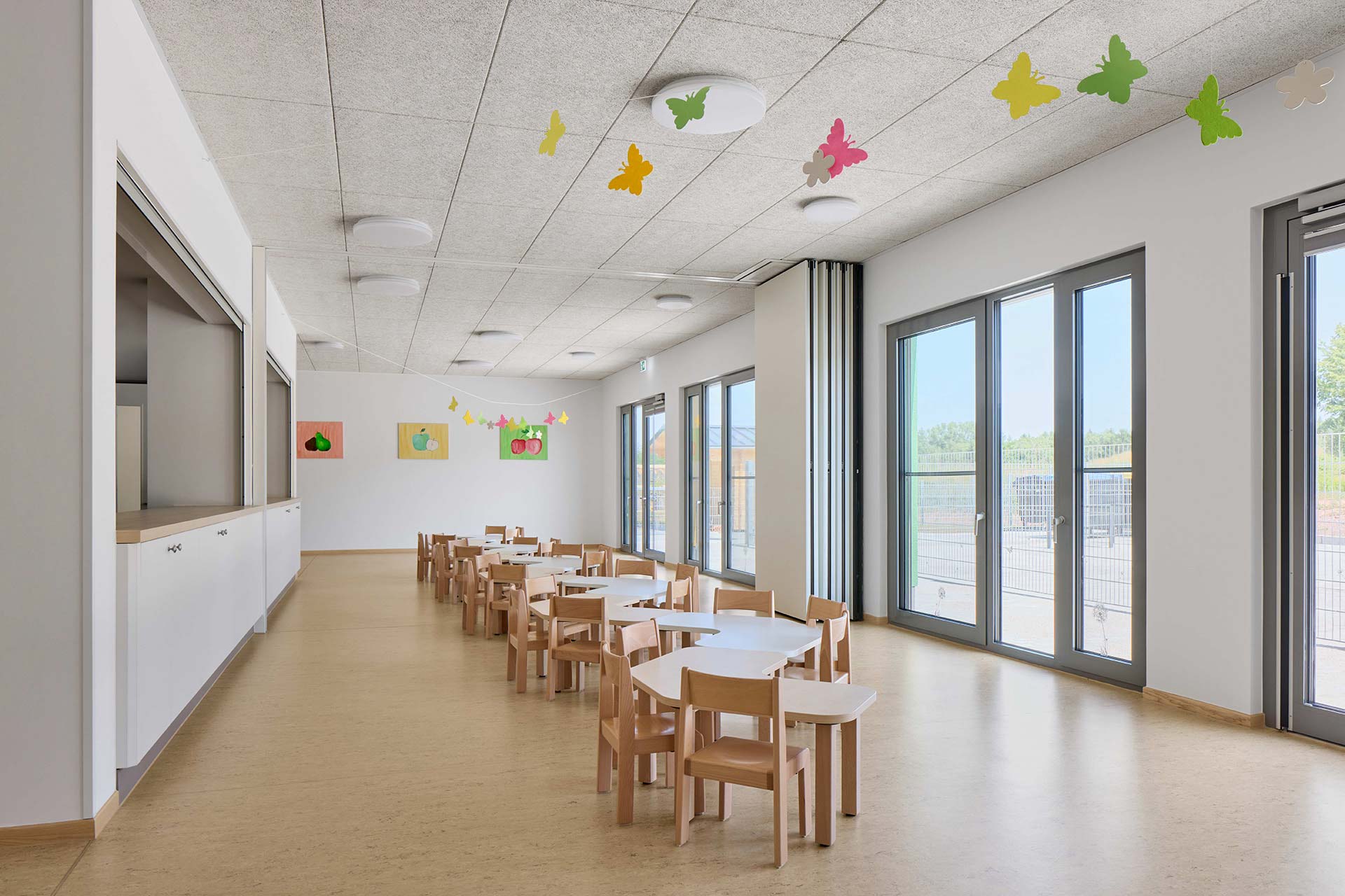 Kinderrestaurant, Küche und Essensausgabe bilden die gemeinsame Mitte der Kita. Eine flexible Raumtrennung erlaubt verschiedene Nutzungen.
