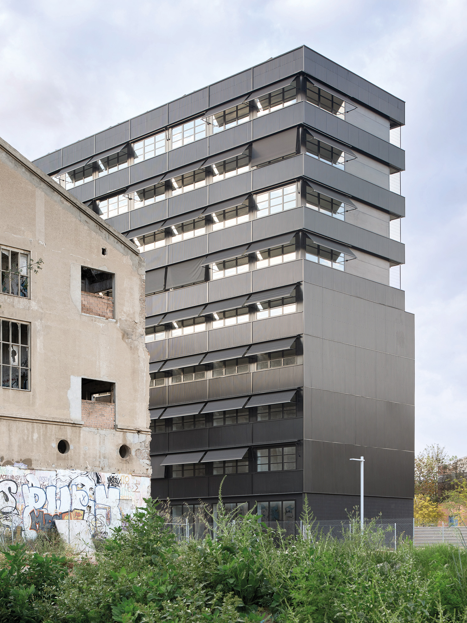 Die geschützte Dachterrasse im obersten Geschoss besteht aus offenen Raummodulen. Aber auch bei den Wohnmodulen sind die Doppelstützen der Stöße außen sichtbar.