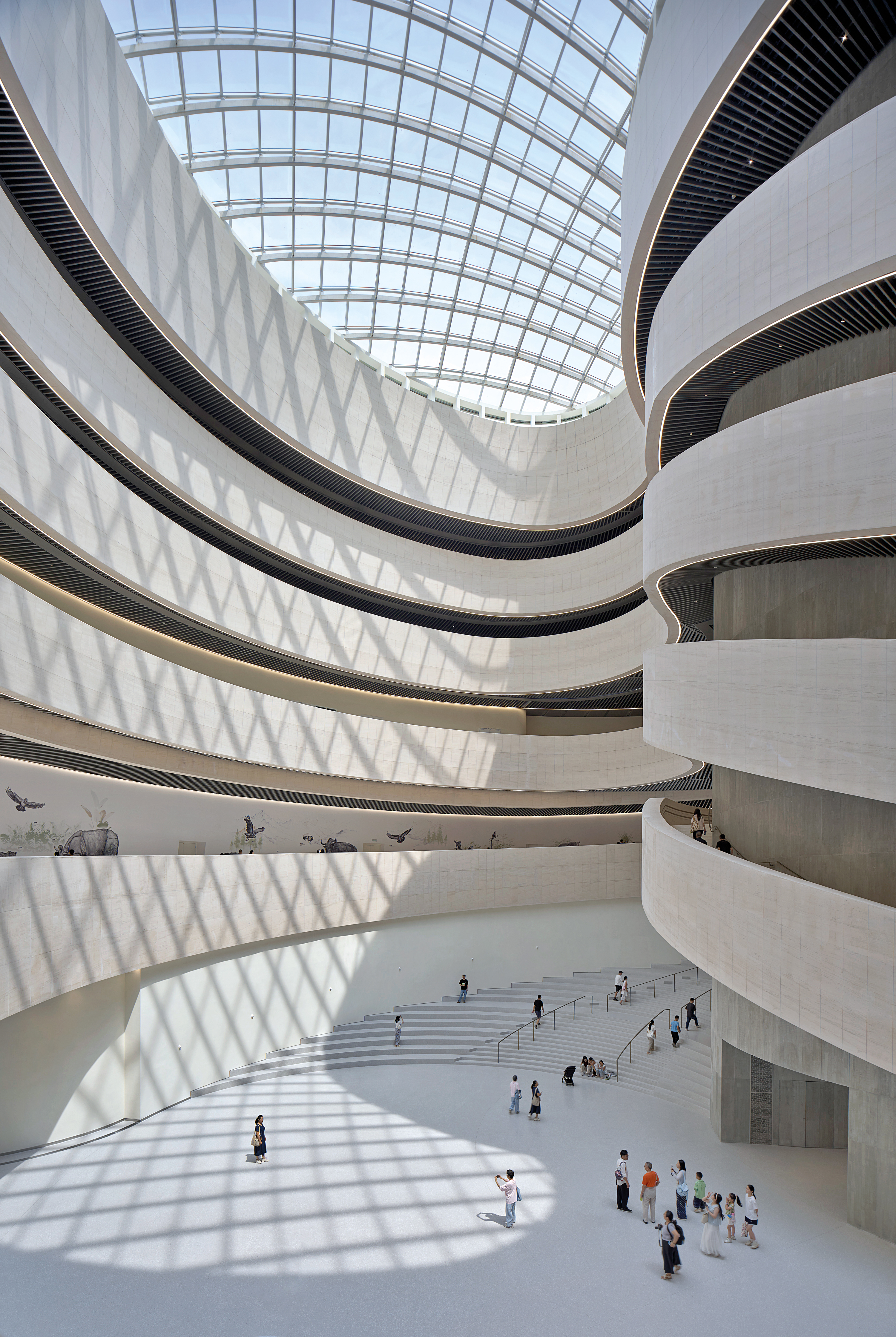 Im Shenzhen Natural History Museum von 3XN und B+H Architects spielen geschwungene Innenwände und kegelförmige Lichtöffnungen auf die Natur des angrenzenden Flussdeltas an. 